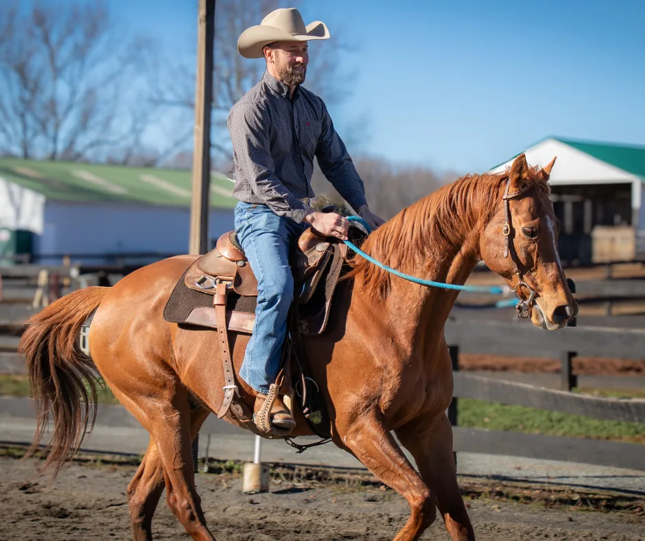 Scott Purdum cantering his chestnut horse in the arena